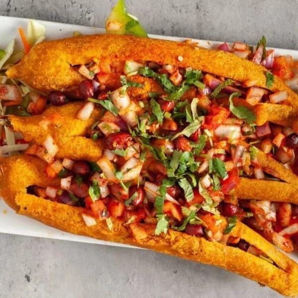 Golden fried Indian chili pakora stuffed with a vibrant mixture of chopped onions, tomatoes, and cilantro.